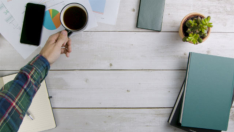 Man-Taking-Cup-of-Coffee-Away-Before-Placing-It-Back-On-Table